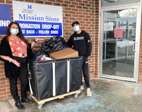 Felipe delivering a bin of clothing to a volunteer at Mission Services