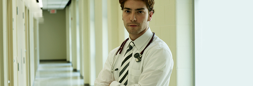 A medical student facing the camera with a hallway in the background