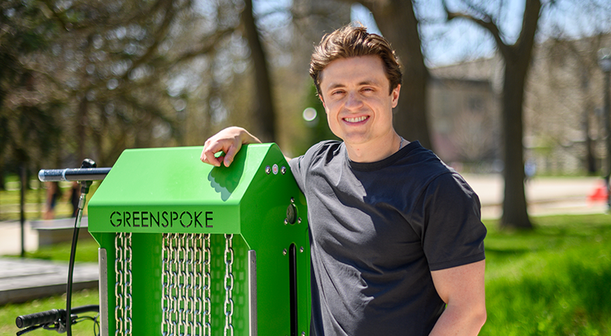 Brandon Brower pictured with a bike repair station on campus