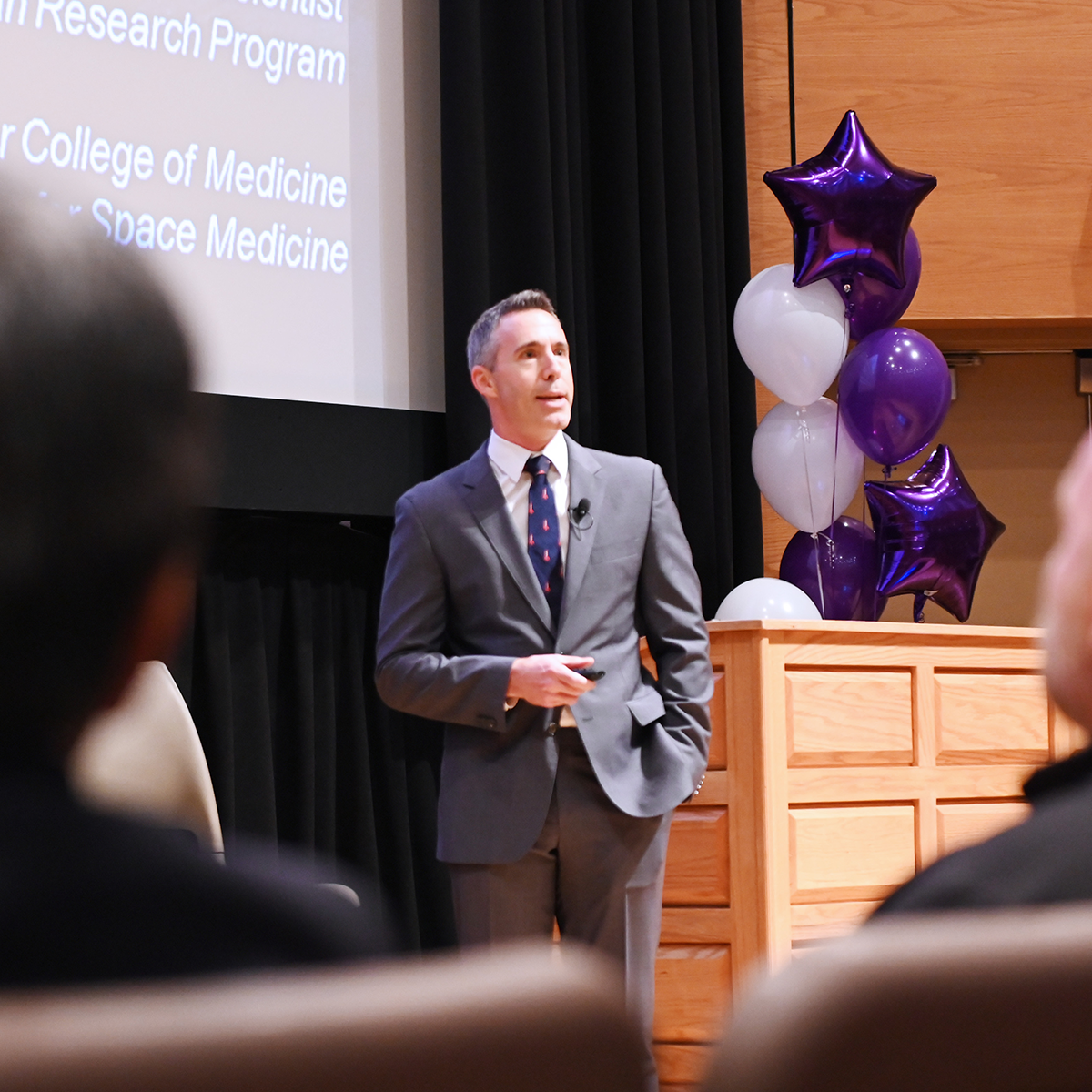 peaker presenting at a Schulich Medicine & Dentistry alumni event with audience in attendance.