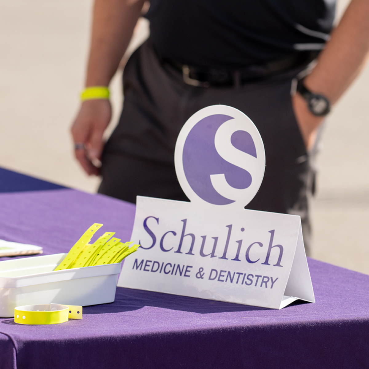 Schulich Medicine & Dentistry welcome table with event registration materials and wristbands.