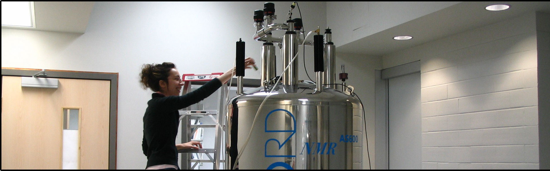 photo of student loading sample into NMR machine