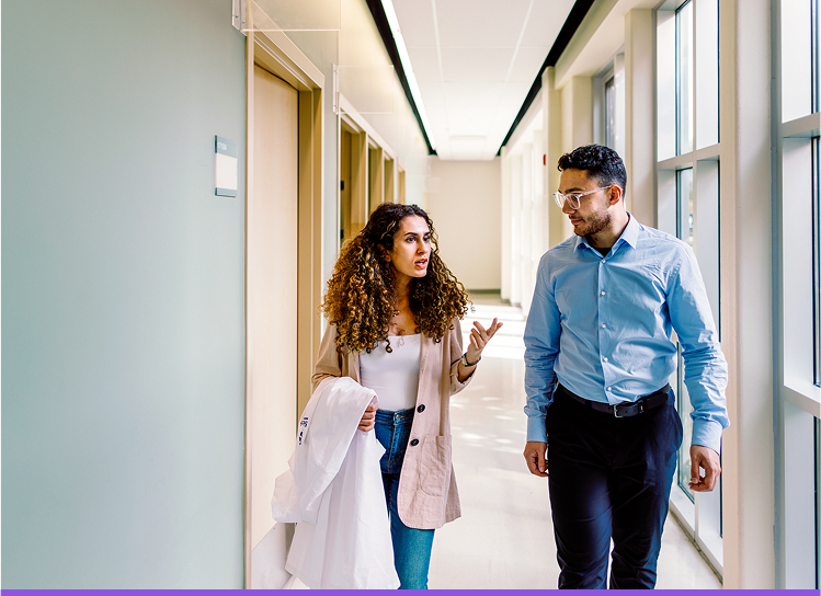 Two students walking in a hallway and talking