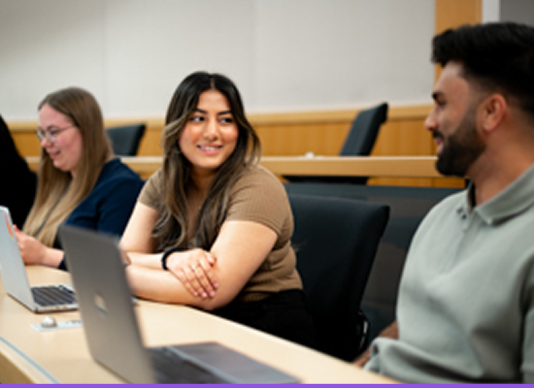 Students in a lecture hall working on laptops