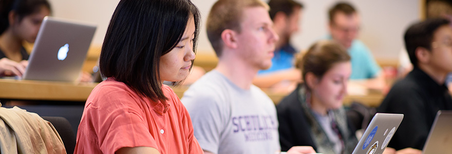 Student in class looking at her laptop