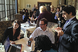 group of people sitting around a round table talking