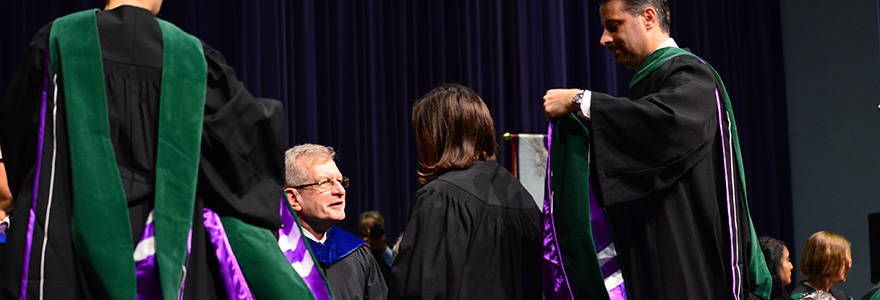 Photograph of a student receiving their graduation hood