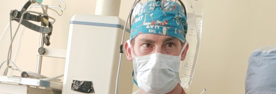 Photo of Dr. Joshua Wiedermann in the operating room wearing a green mask.