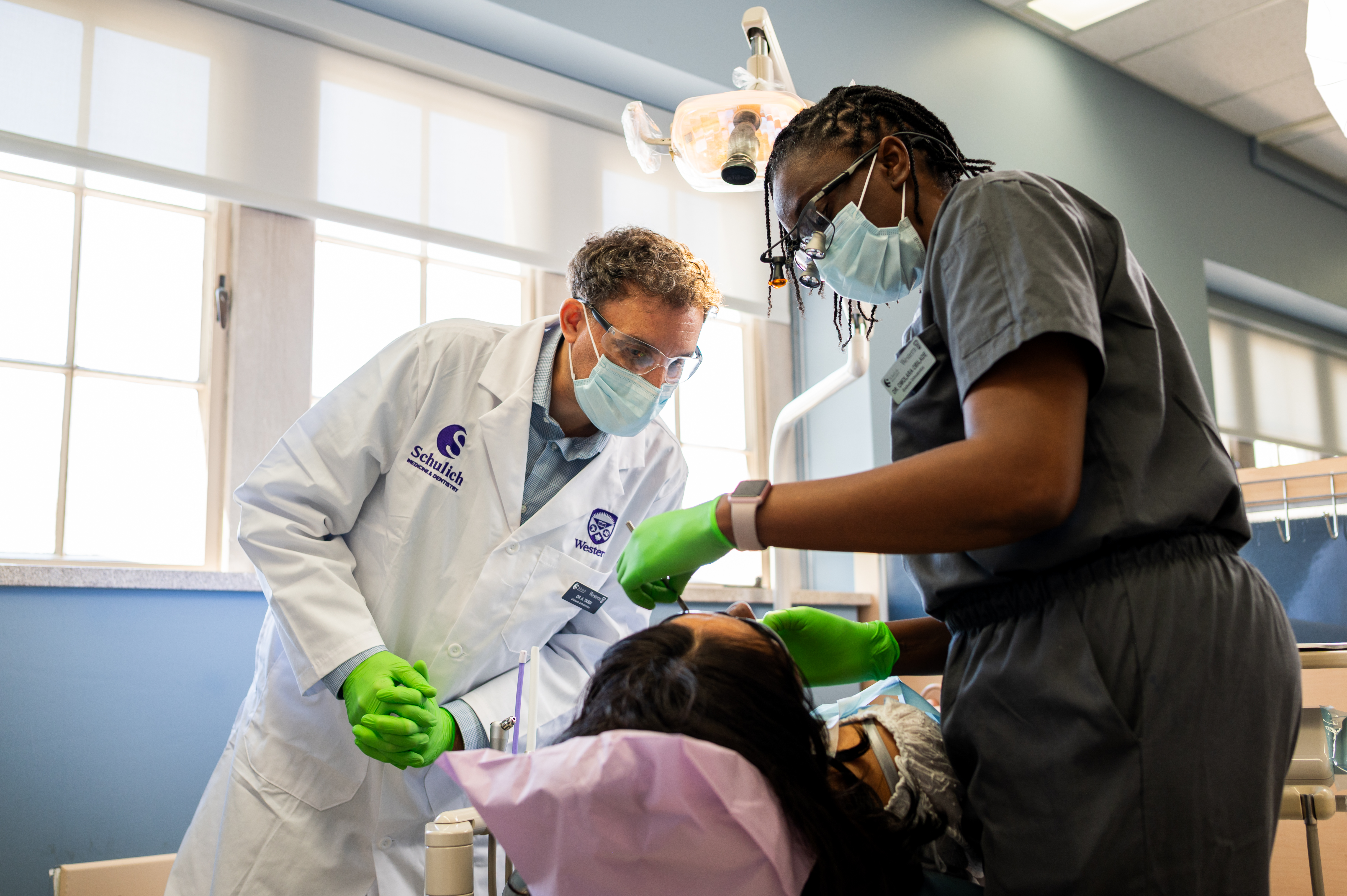 Resident performing clinical work on a patient under faculty supervision