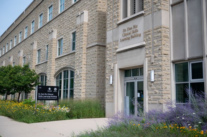 Clinical Skills Building entrance with flowers along the walkway