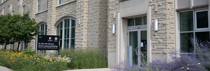 Clinical Skills Building entrance with flowers along the walkway