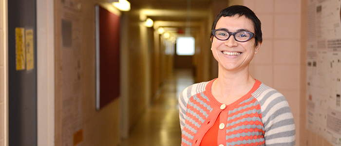 Monica Guzman smiling for the camera in a hallway.
