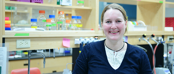 Ilka Heinemann smiling for the camera in front of a lab bench.