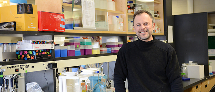Dean Betts smiling for the camera at a lab bench.