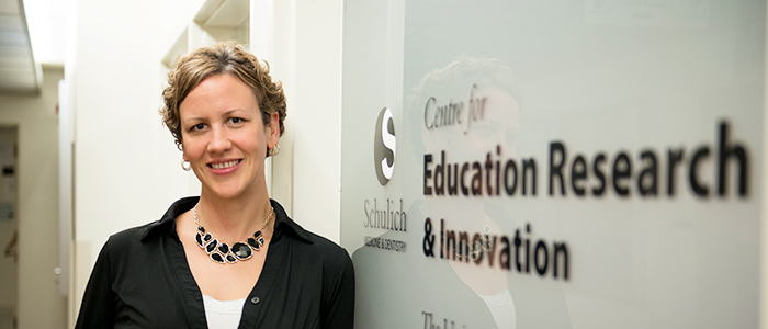 Stacey Espinet smiling for the camera next to CERI sign.