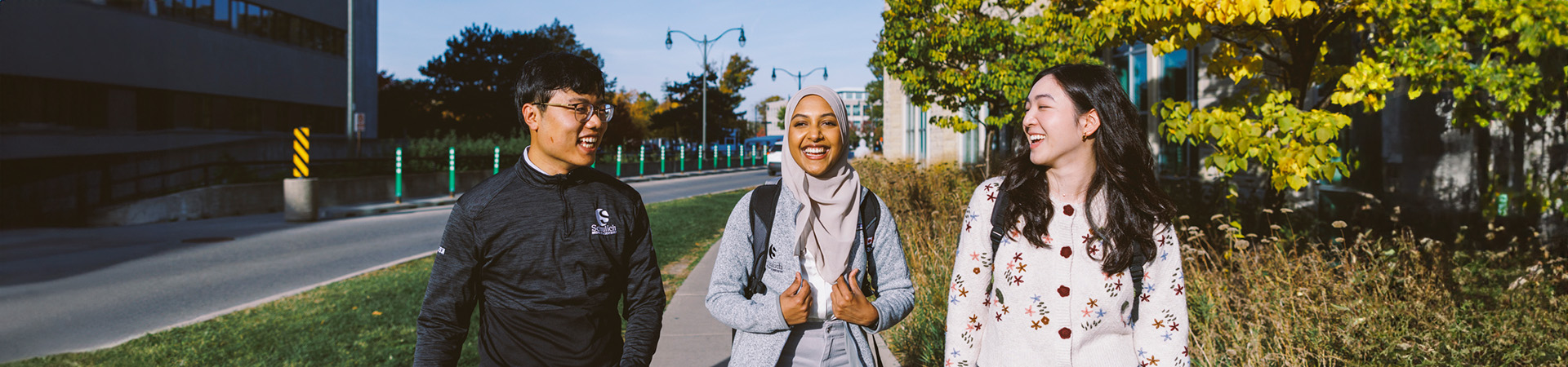 Three Schulich students walking on campus and chatting.