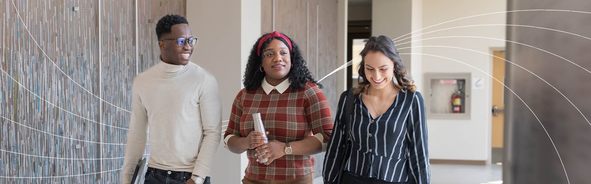 Three students walking and talking in a bright hallway, smiling and holding notebooks and a water bottle, with white curved graphic lines layered over the image background.