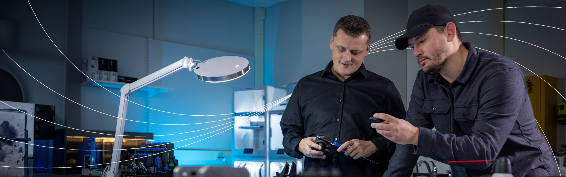Two researchers examining equipment in a laboratory workspace.