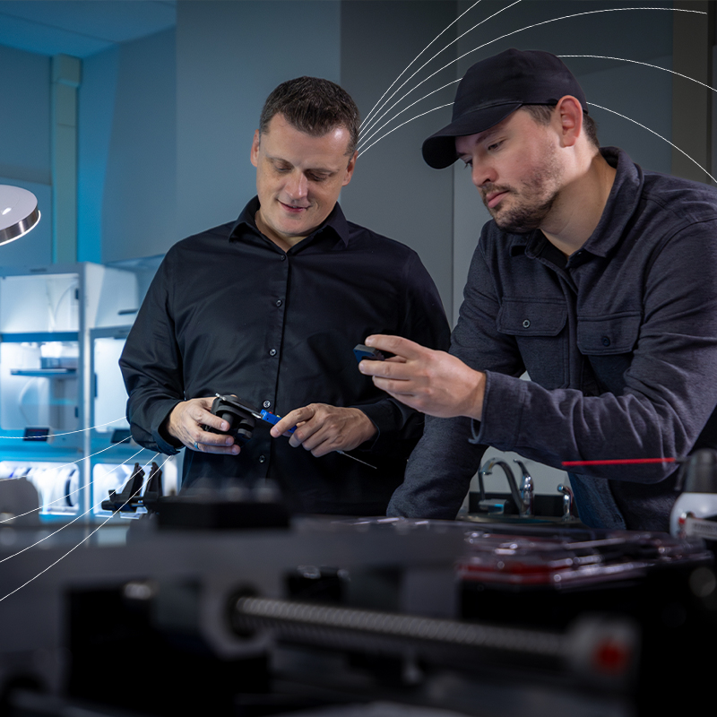 Two researchers examining equipment in a laboratory workspace.