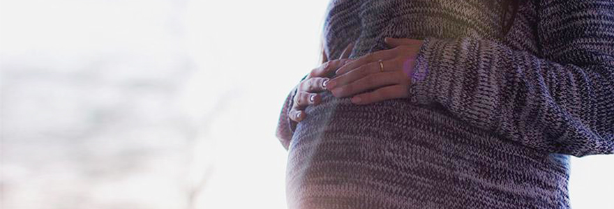 Close-up photo of mother's hands on her pregnant belly
