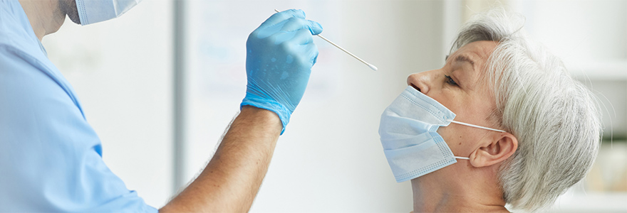 Image of health care worker about to insert swab into the nose