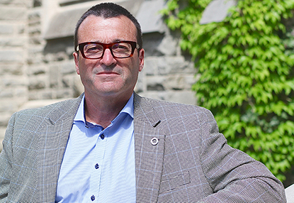 Photo of Dr. Charles Weijer in front of an ivy-covered wall on Western's campus