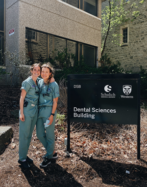 Eibhlin posing with a friend outside the Dental Sciences Building