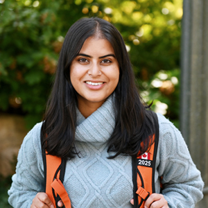 Nadia Khan posing with an orange backpack