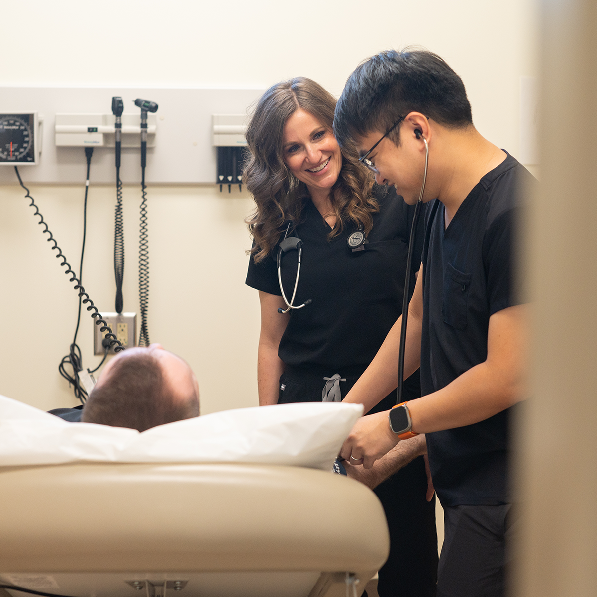 Medical trainees examining a patient in a clinical setting.