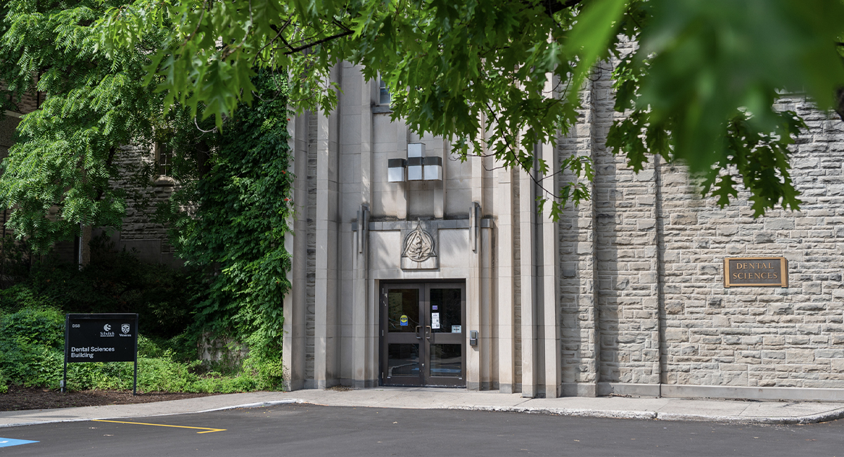 Dental Sciences Building entrance framed by leafy trees