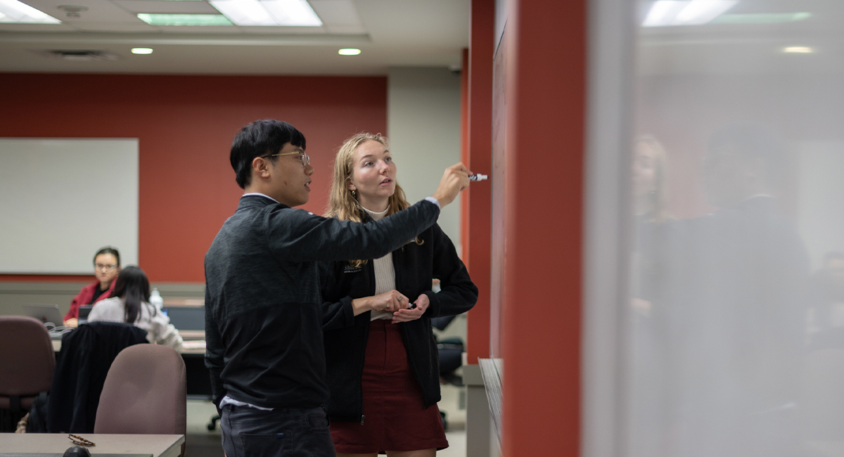 Instructor pointing while speaking to students in a classroom