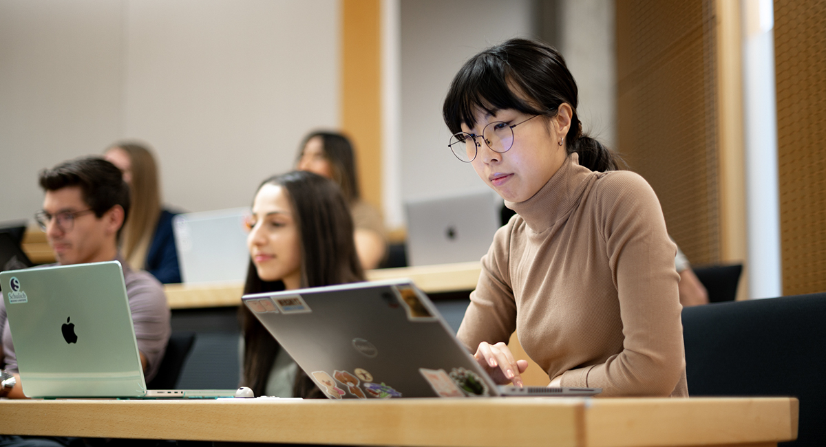 Student working on a laptop during a lecture