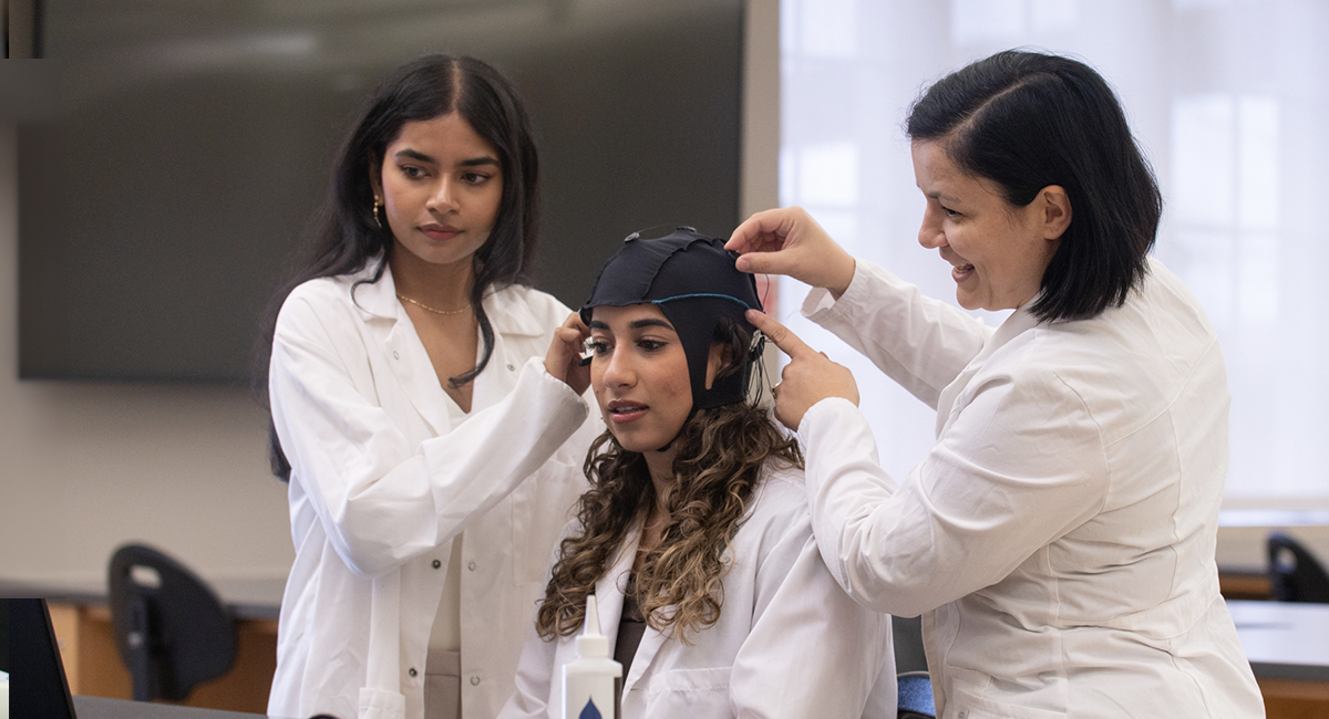 Instructor helping a student adjust lab equipment during a class