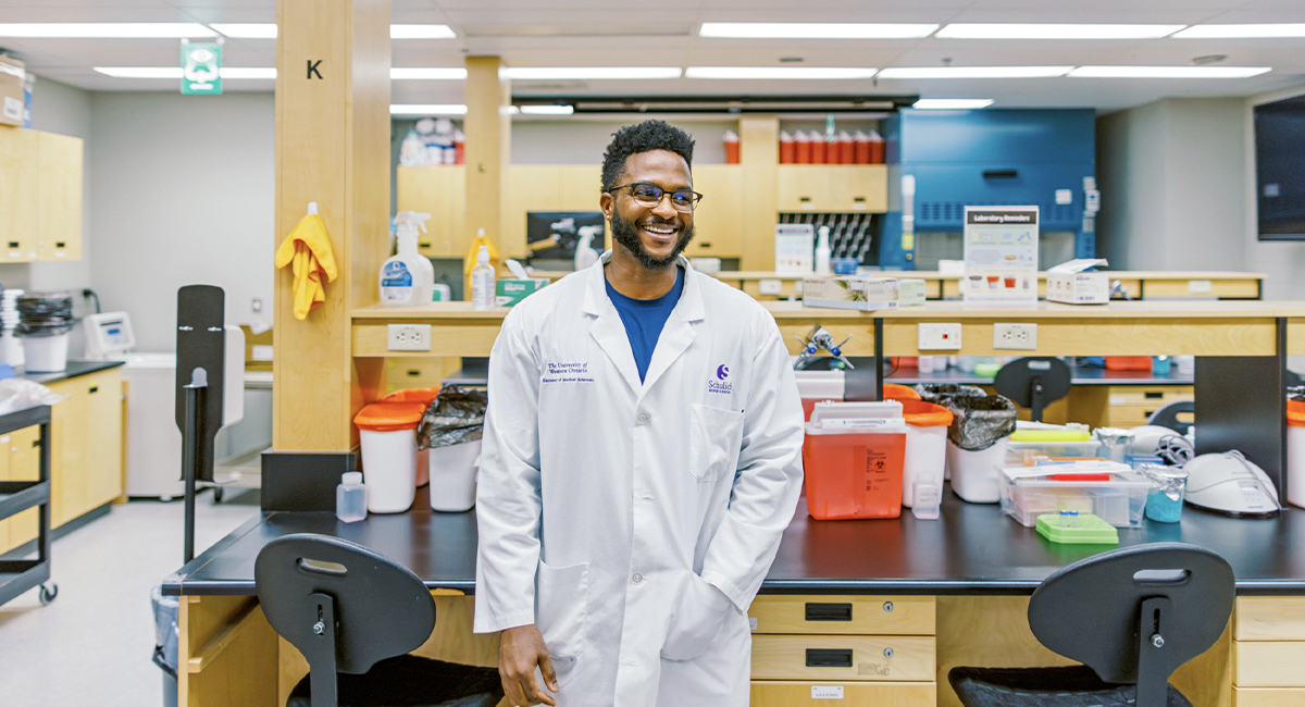 Instructor in a lab coat standing in a biomedical lab