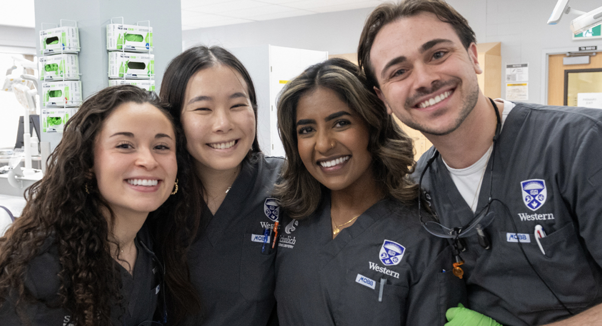 Dentistry students in clinic attire posing for a group photo