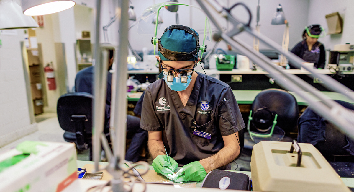 Dental student working at a skills lab station with equipment