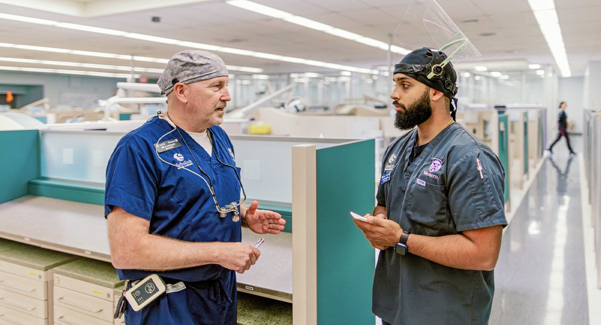 Instructor speaking with a dentistry student in a clinical setting