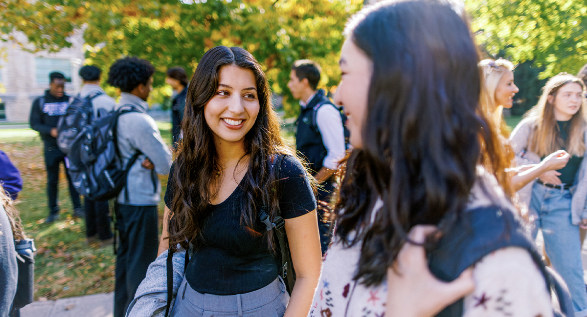 Students talking outdoors on campus in autumn