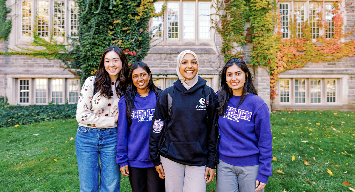 Group of students standing together on a campus lawn