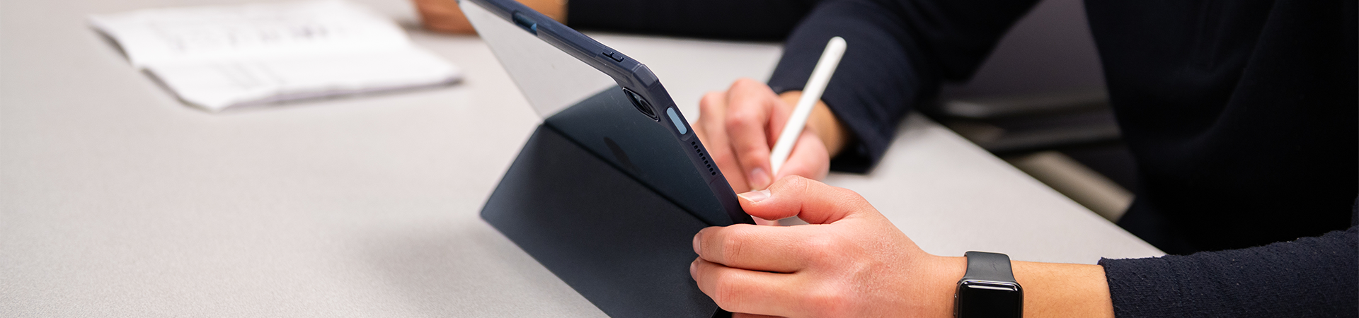 Medical students taking notes on a tablet