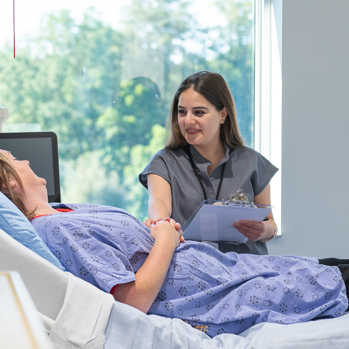 a patient assessment shot with the resident at bedside taking vitals