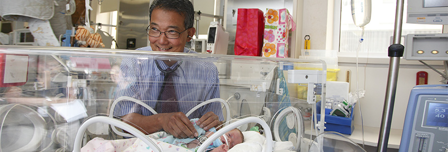 Dr Victor Han standing near an incubator