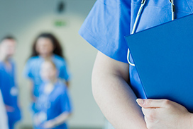 Photograph of physcian standing with folder