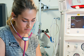 Medical student standing near an incubator