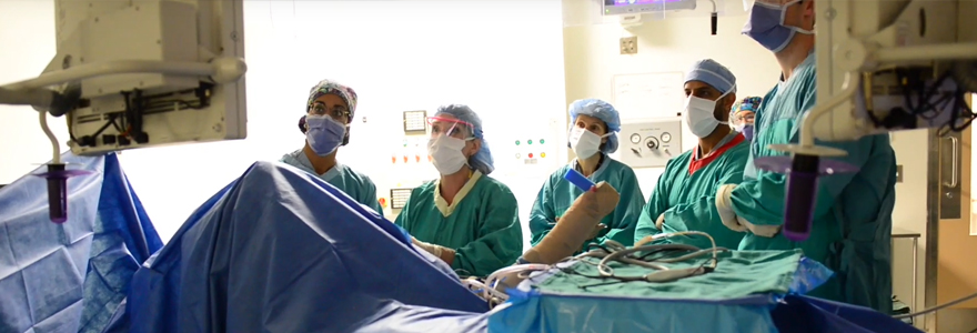 Group of surgeons standing around a patient in the OR
