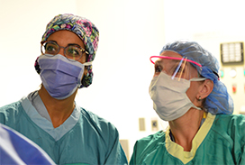 Photograph of two faculty member wearing green in the OR
