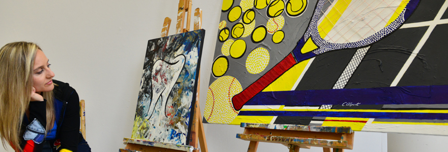 Photo of Caroline Alpert with her paintings.jpg