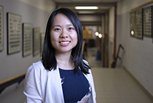 Photograph of Christine Huynh standing in the hallway